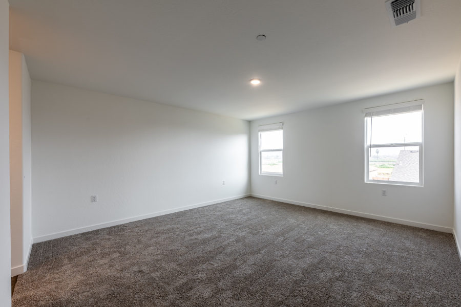 A room with a carpet and windows.