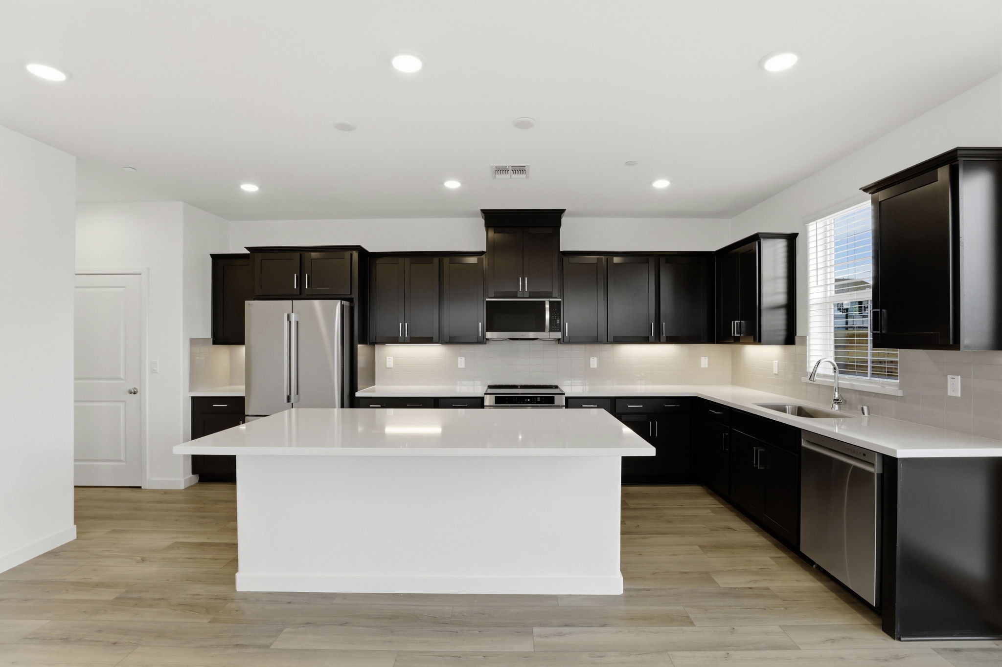 A kitchen with black cabinets.