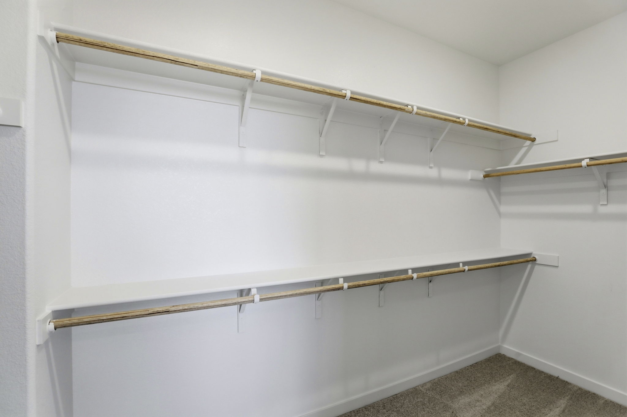 A white wall with a metal bar.