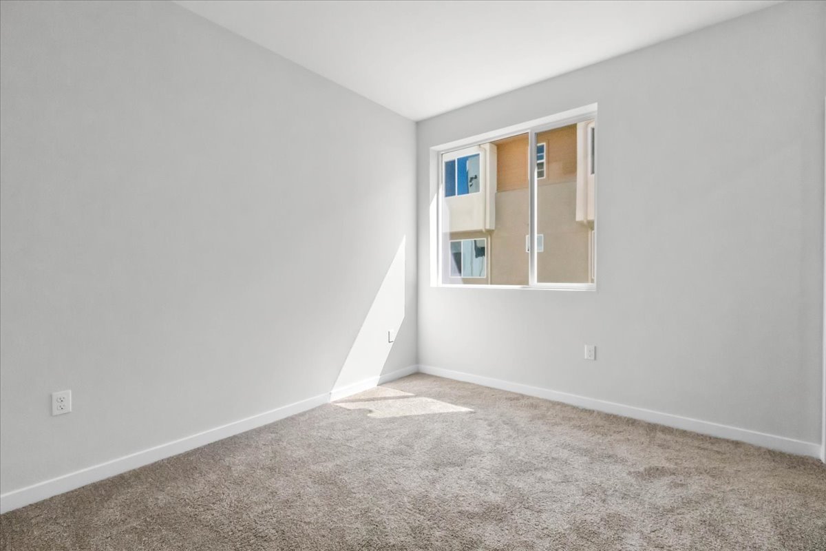 A room with a window and carpet.