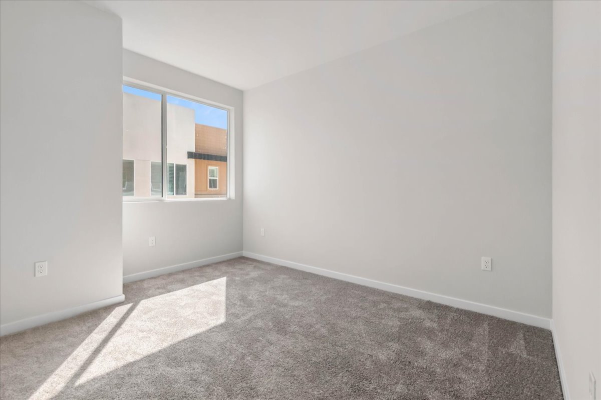 A room with a carpet and a window.