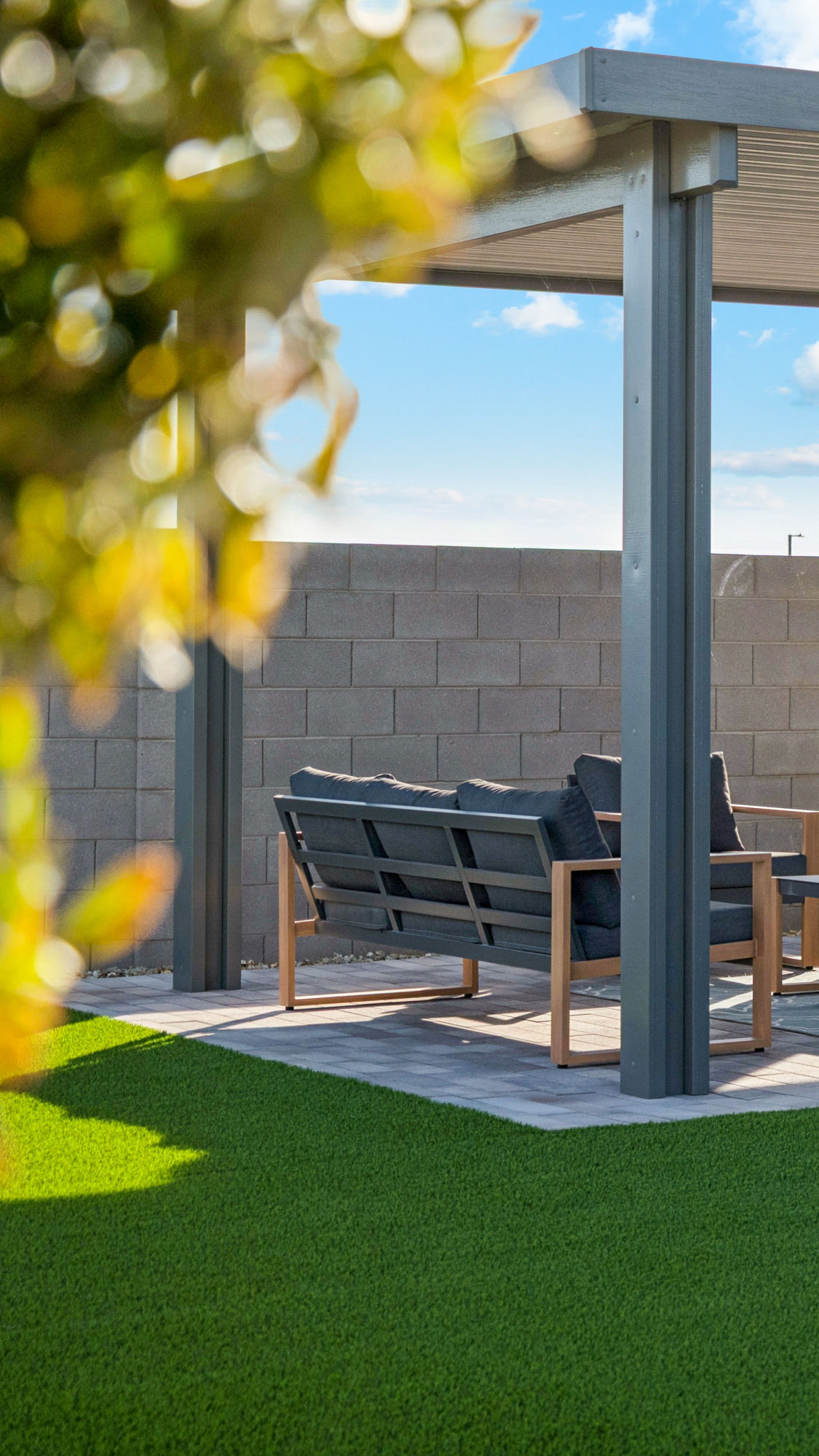 Photo of model home backyard with plenty of turf, patio furniture and mature foliage in Casa Grande AZ- New Construction Home For Sale by Century Communities with community amenities