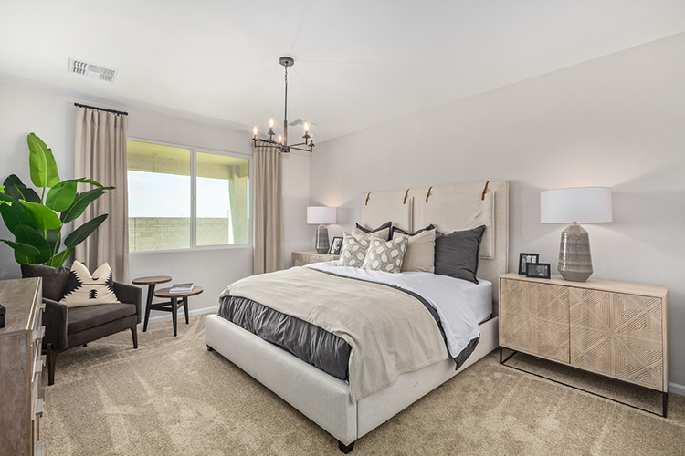 A bedroom with a bed and lamps.