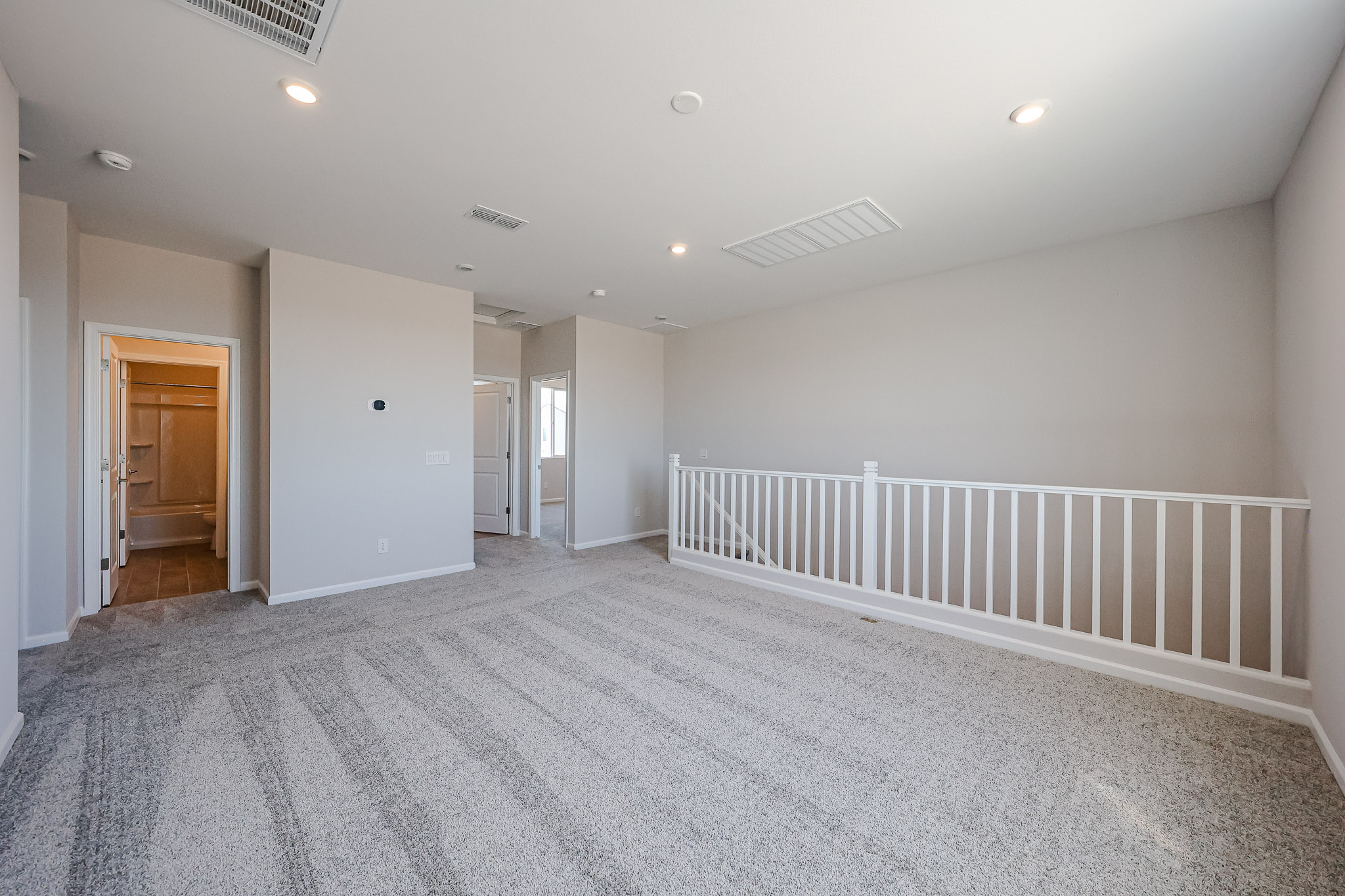 A room with white walls and a white railing.