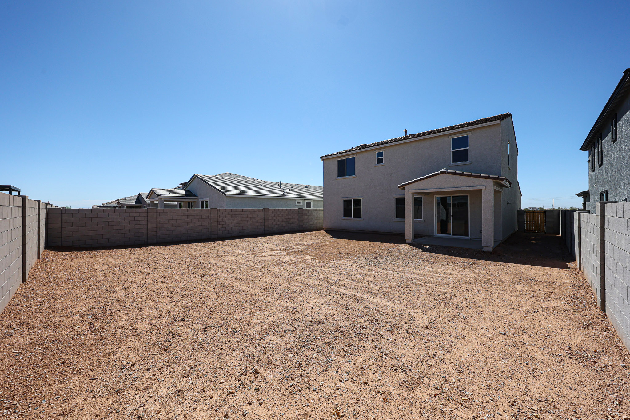A dirt area with buildings in the background.