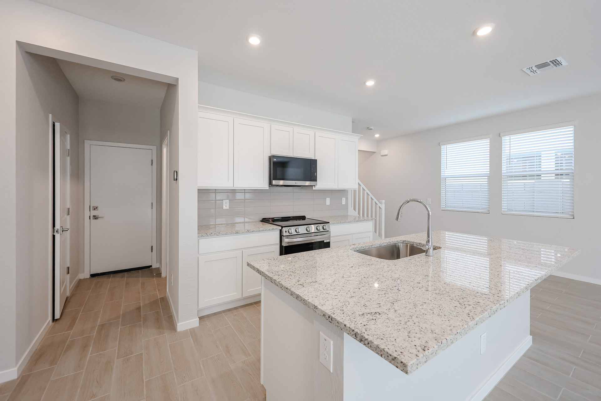 A kitchen with white cabinets.