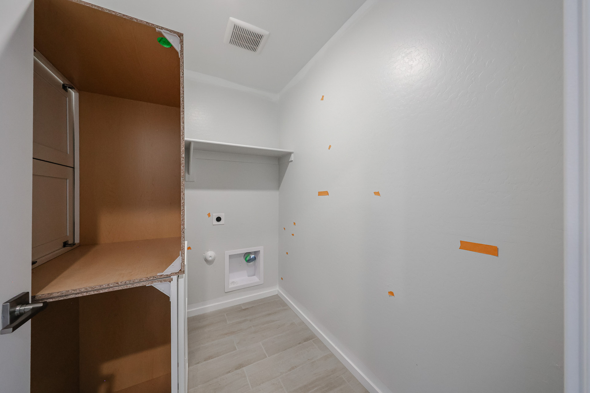 A room with a white wall and a wood floor.