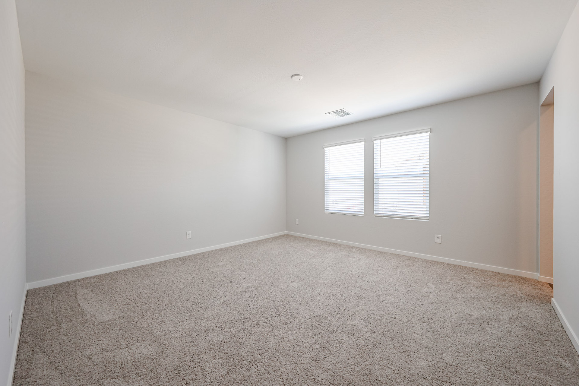 A room with a carpet and windows.