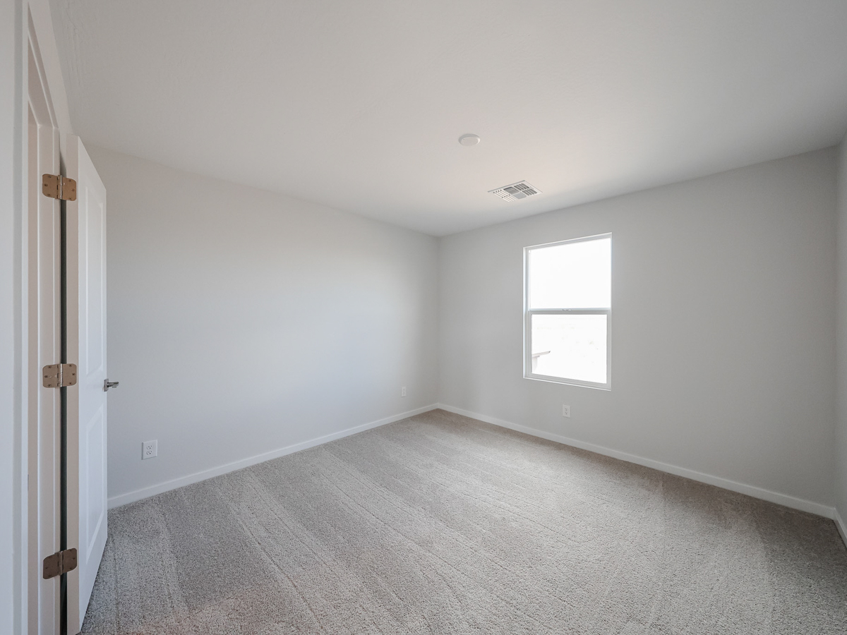 A room with a carpet and a window.