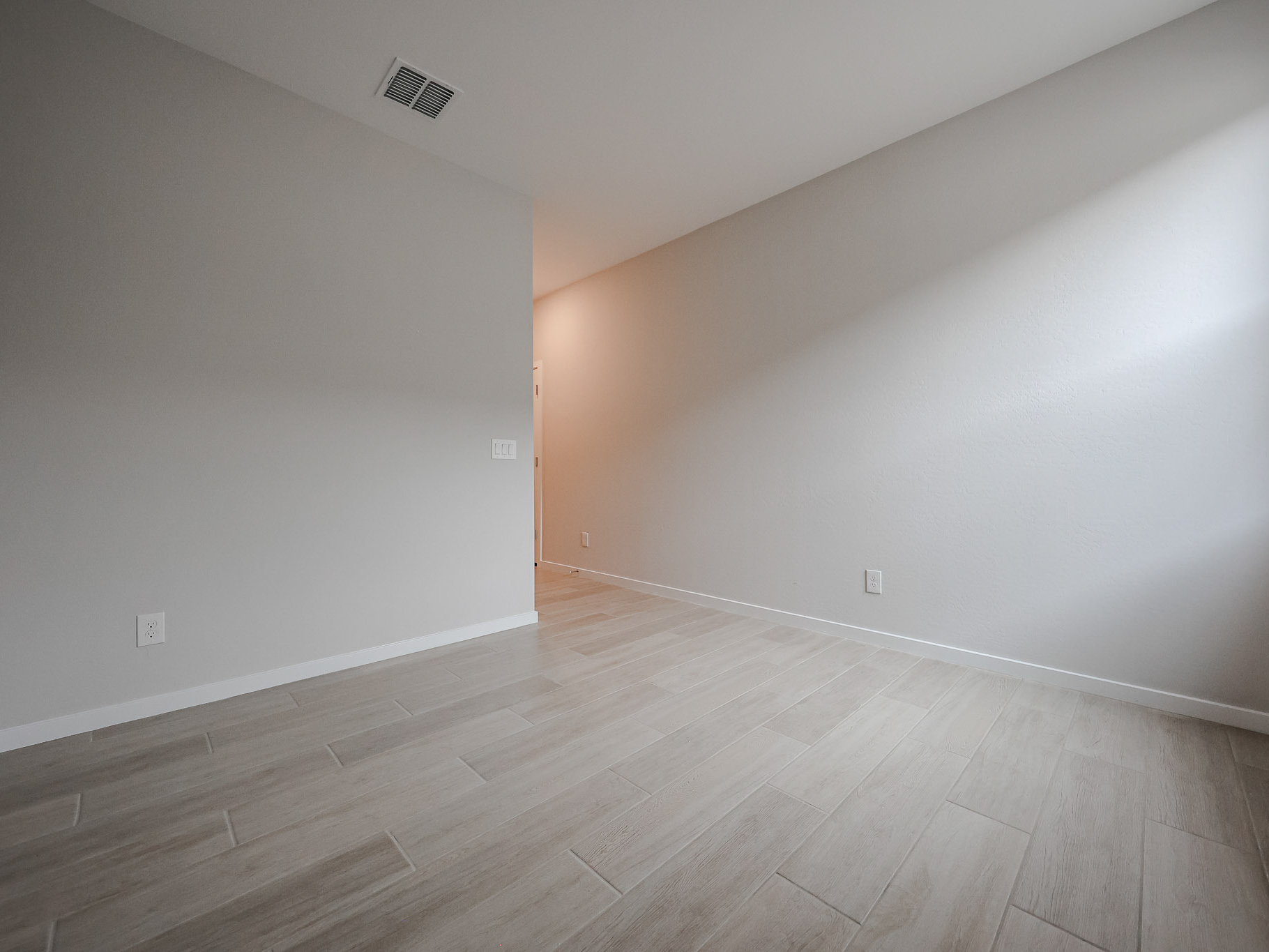 A room with a wood floor and a white wall.