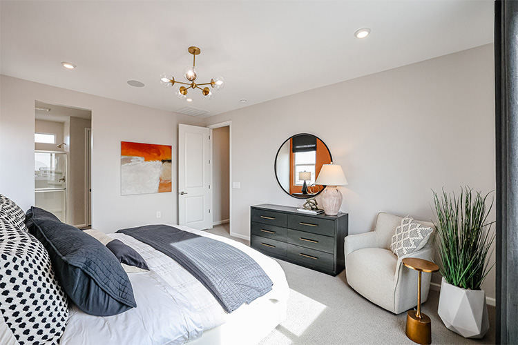 A bedroom with a bed and a chair.