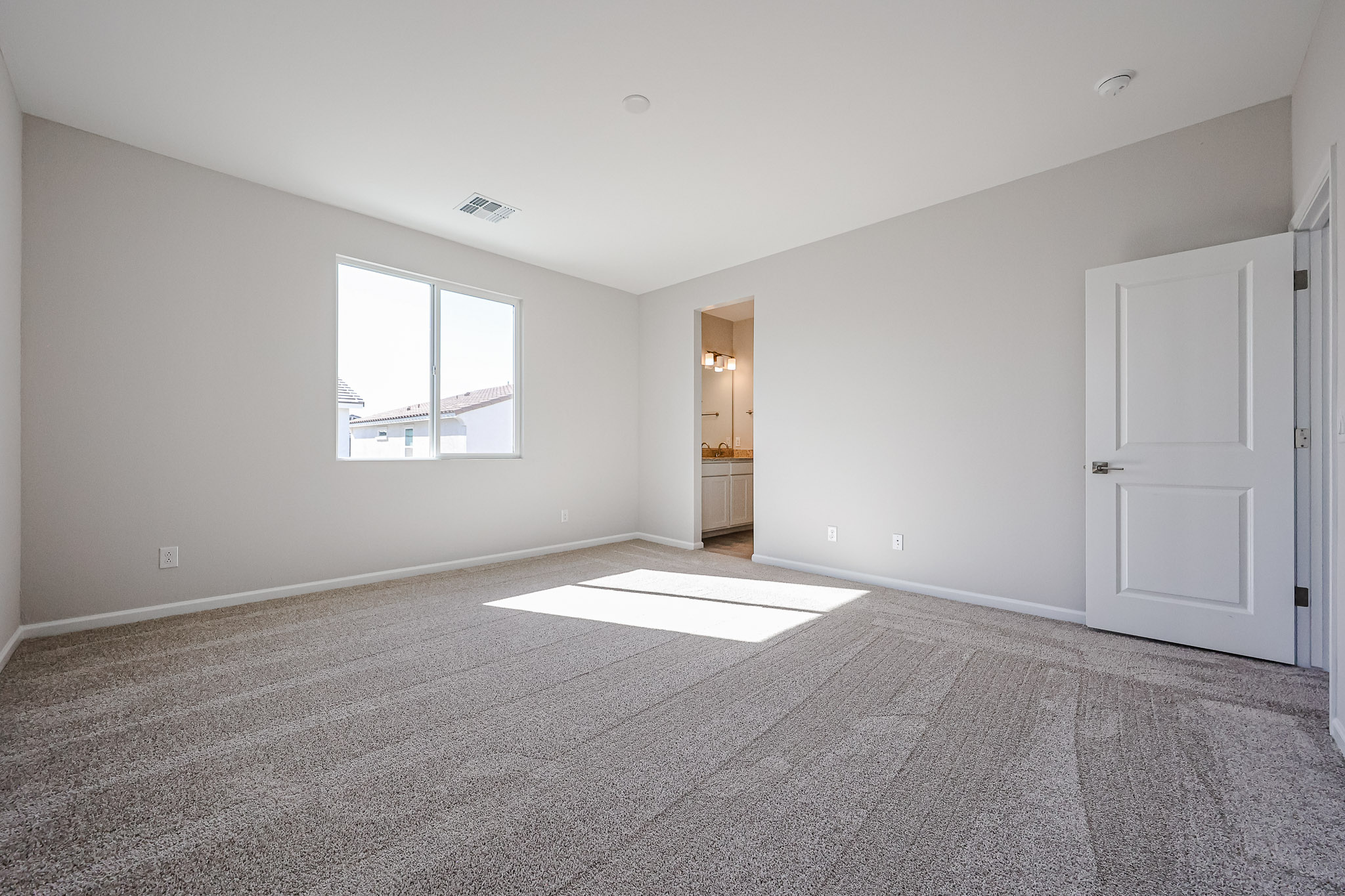 A room with a carpet and a door.