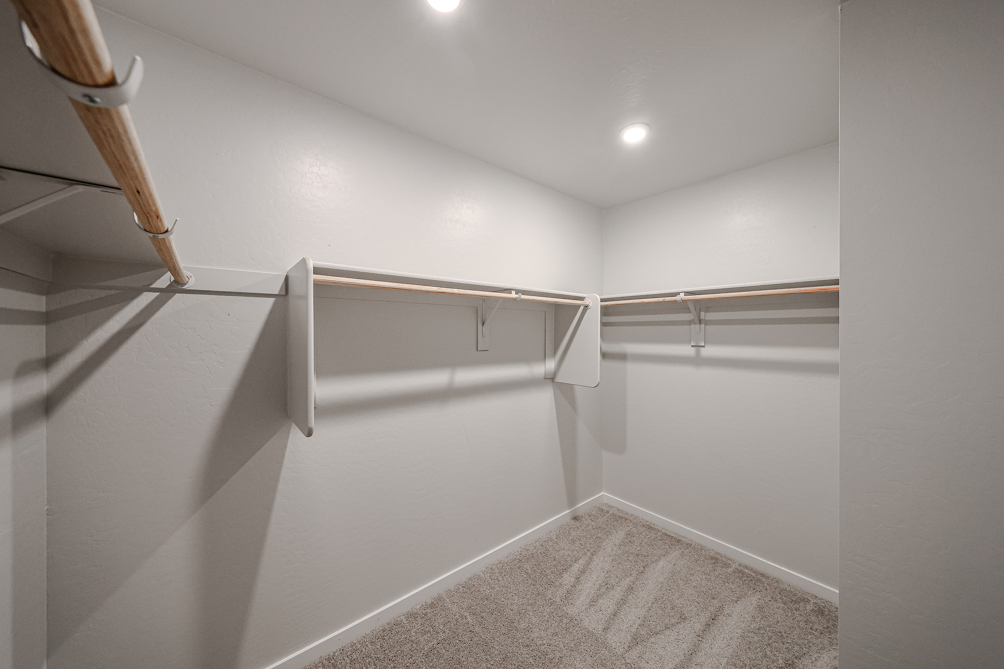 A white hallway with a metal railing.