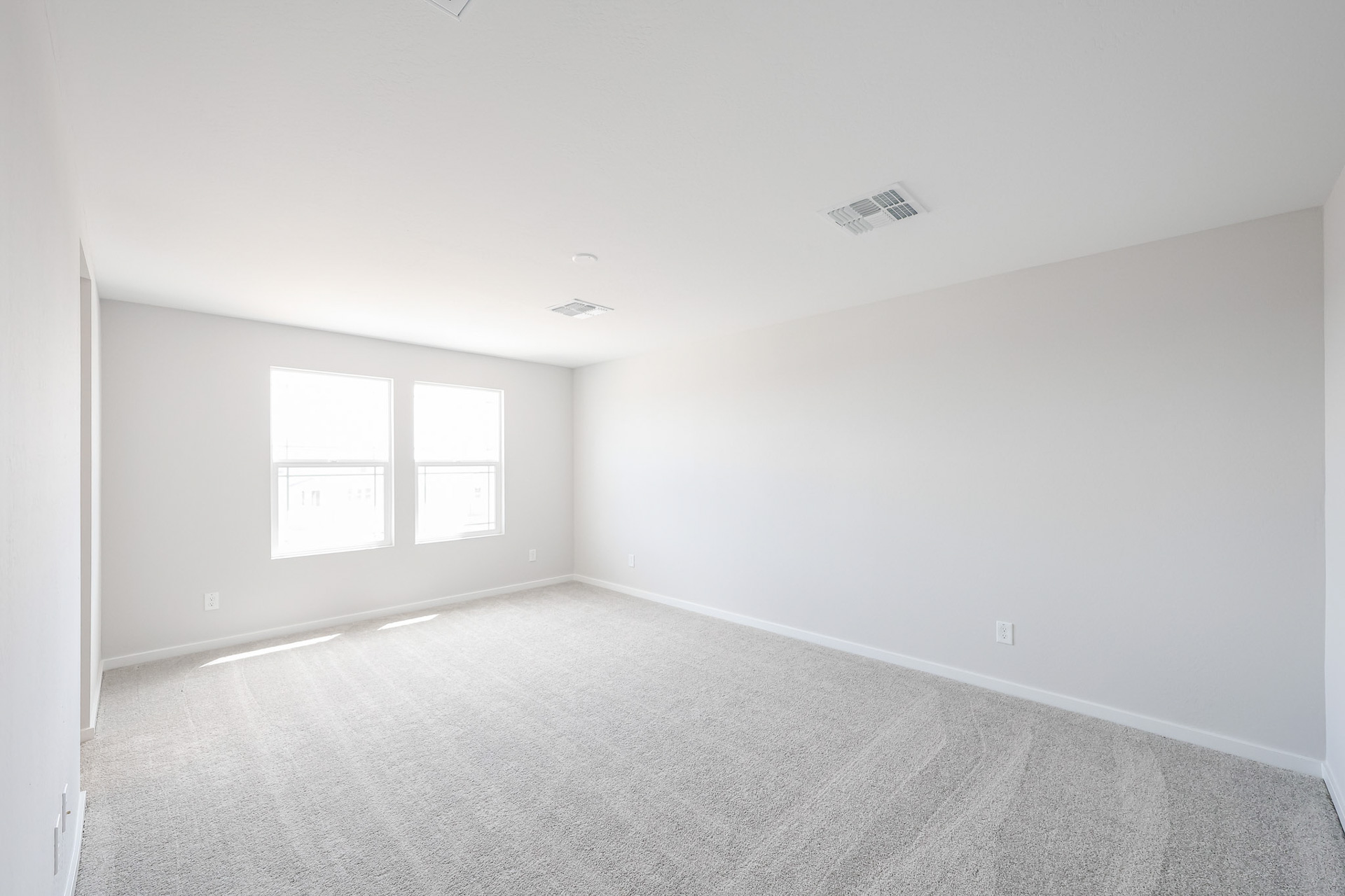 A room with a carpet and windows.