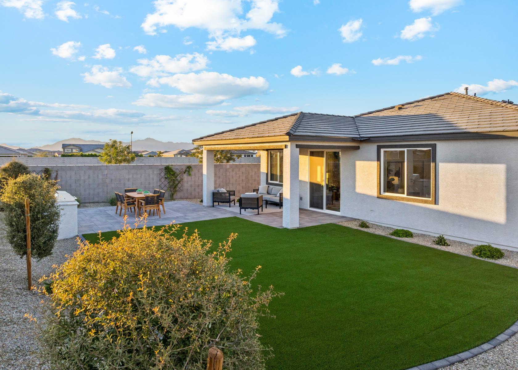 A house with a lawn and a table and chairs.