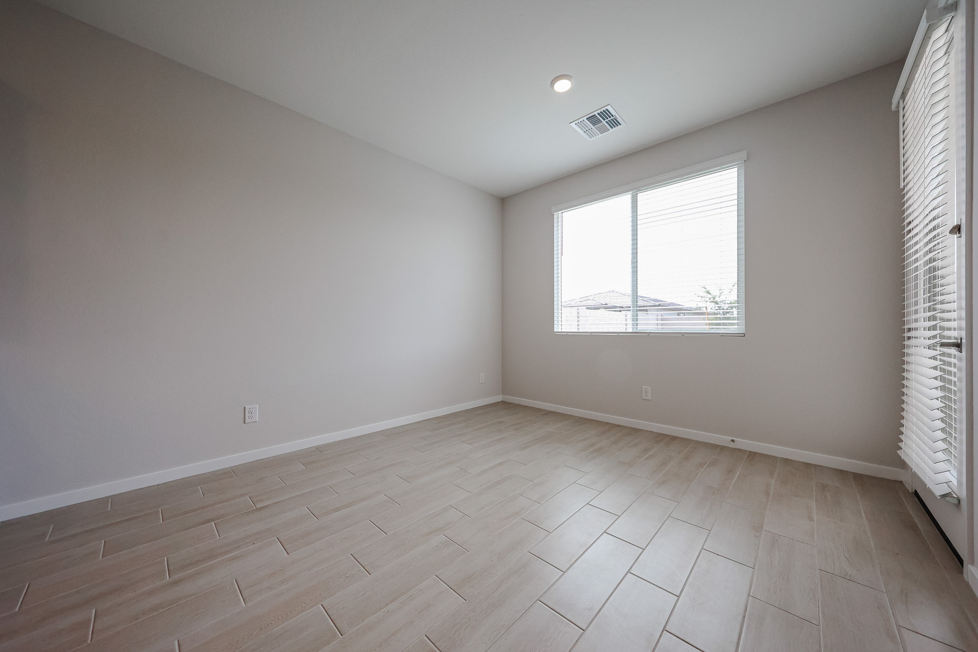 A room with a wood floor and a window.