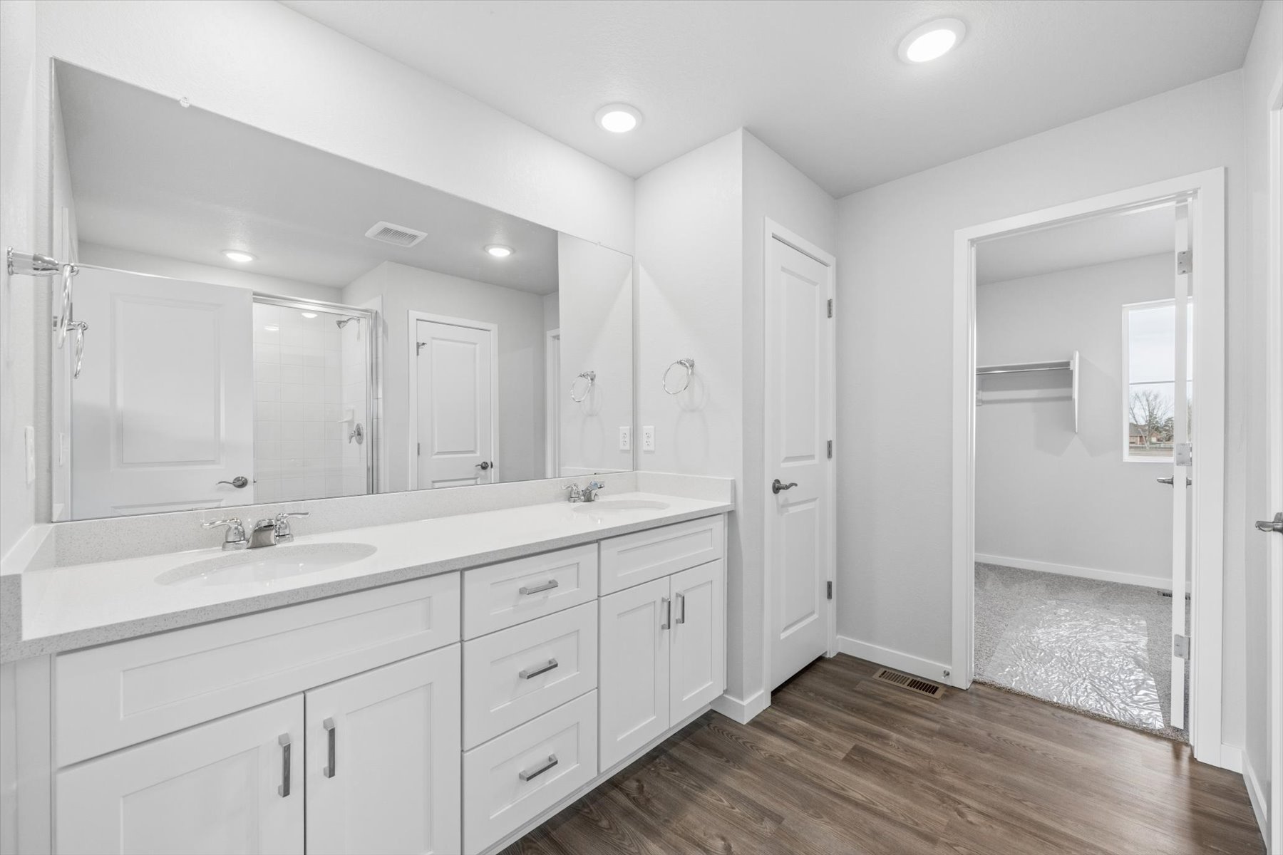 A bathroom with white cabinets.