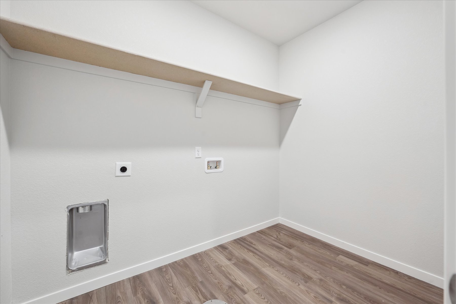 A room with a wood floor and white walls.