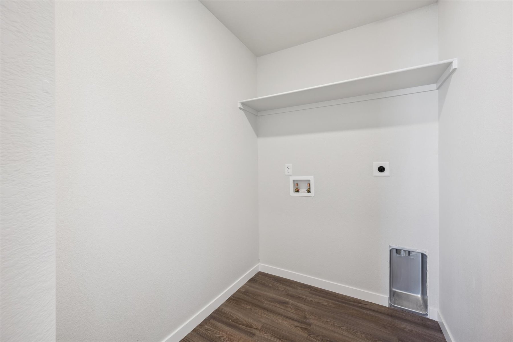 A white room with a wood floor.