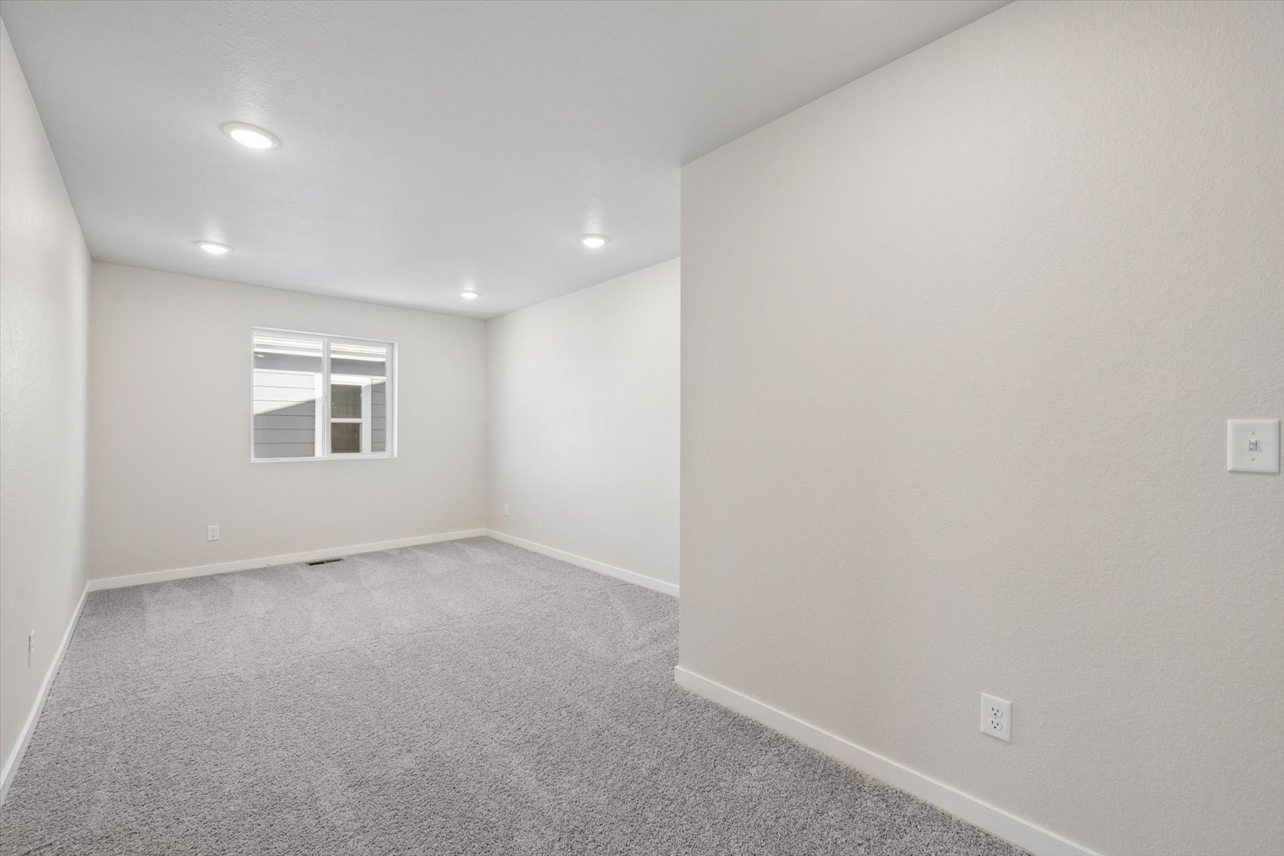 A room with a window and a carpet.