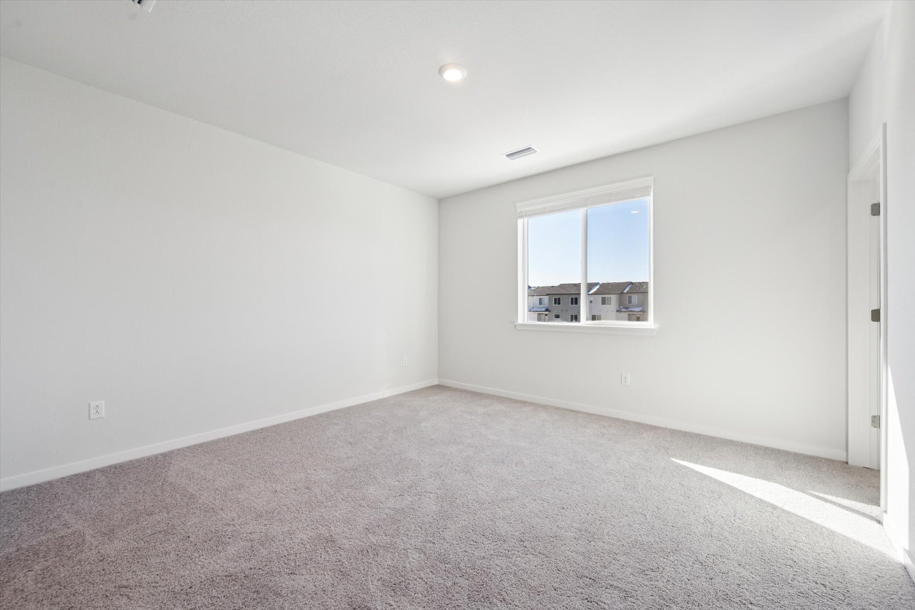 A room with a window and a carpet.