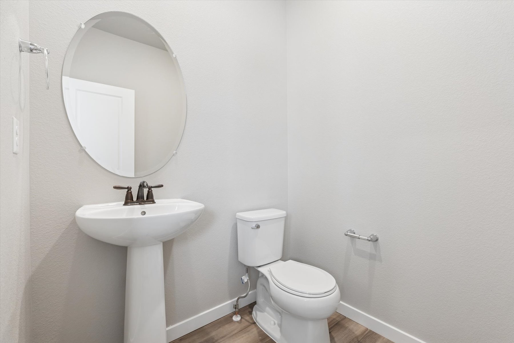 A bathroom with a round mirror.