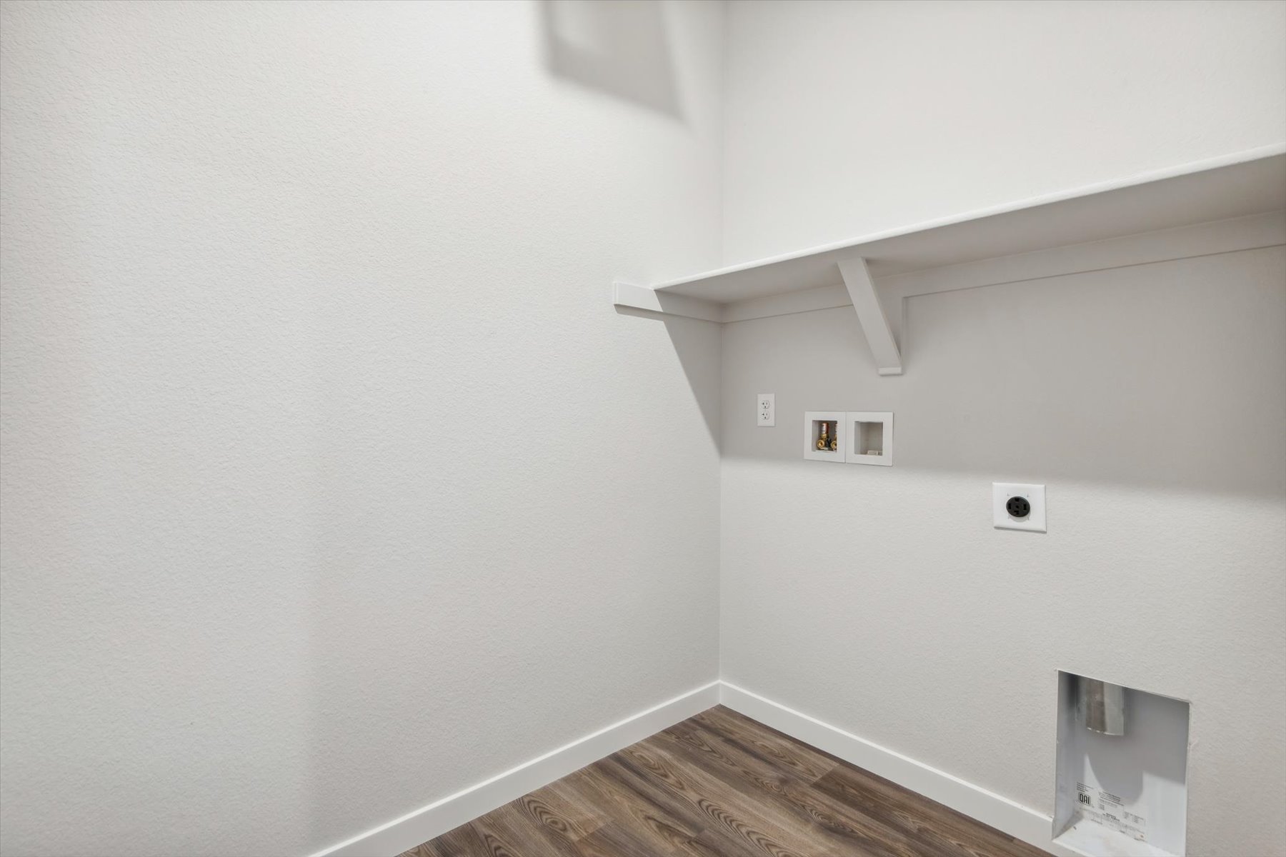 A white wall with a wood floor.