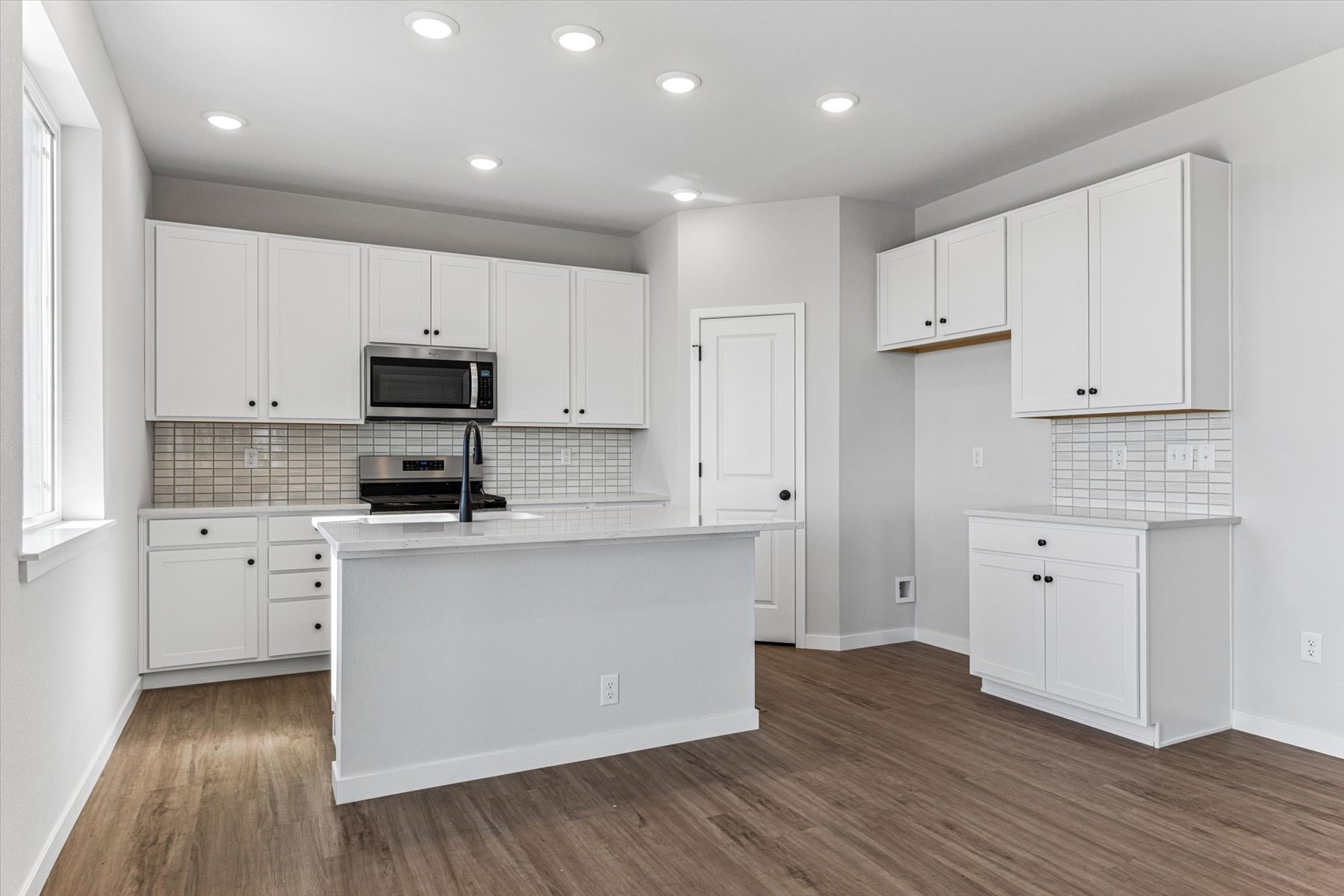 A kitchen with white cabinets.