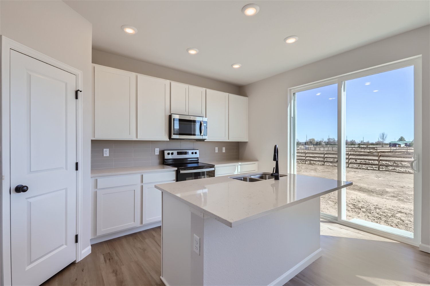 A kitchen with white cabinets.