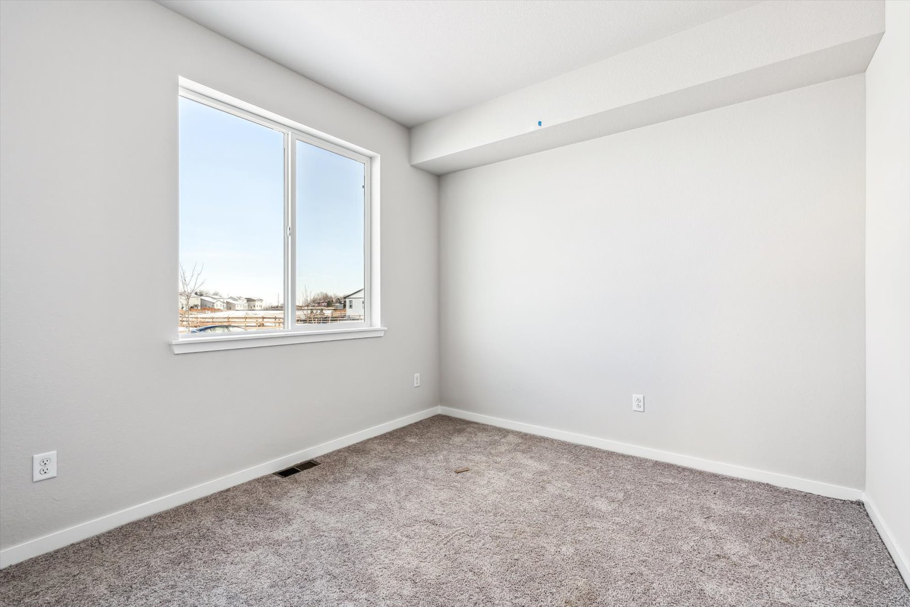 A room with a window and a carpet.