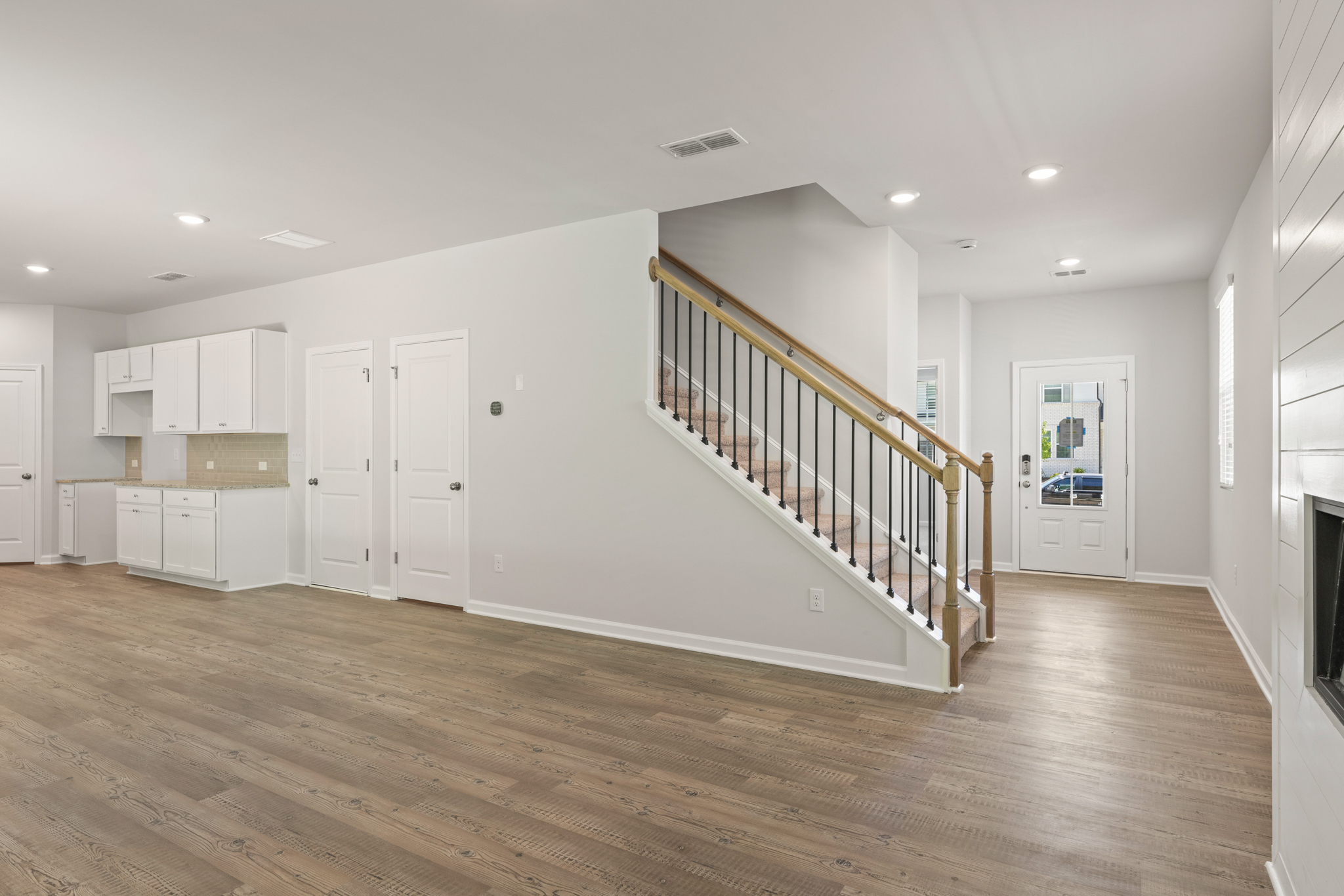 A long hallway with white doors.