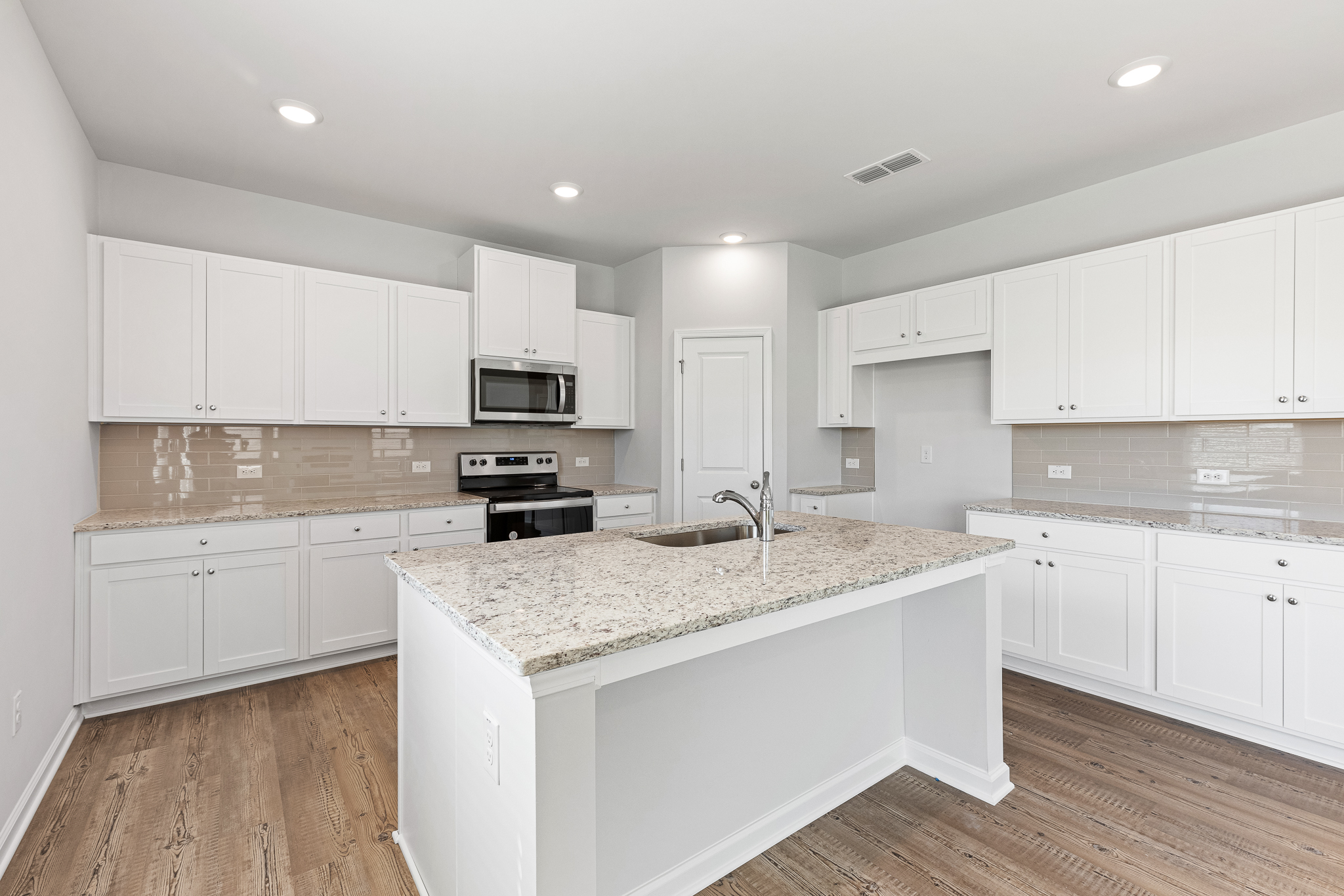 A kitchen with white cabinets.