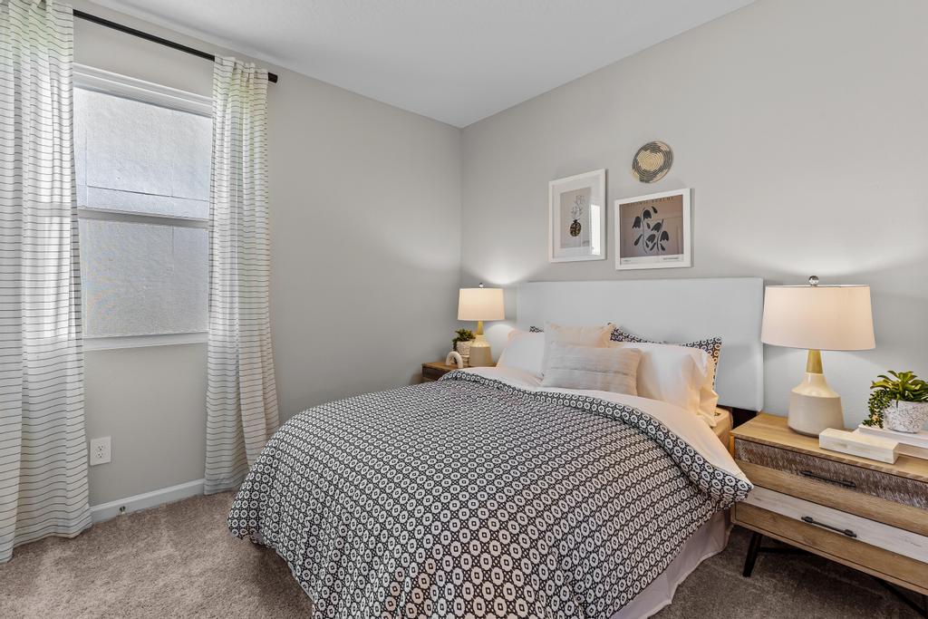 A bedroom with a bed and lamps.