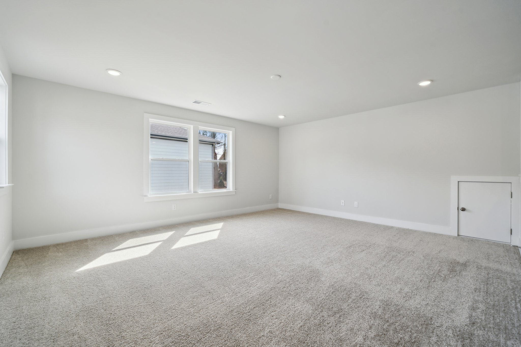 A room with a carpet and a window.