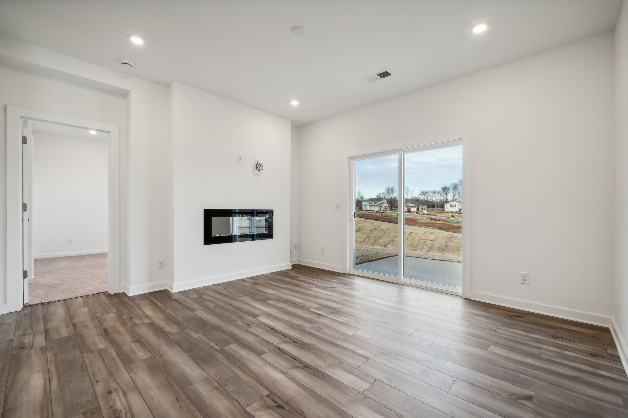 A room with a wood floor and a large window.