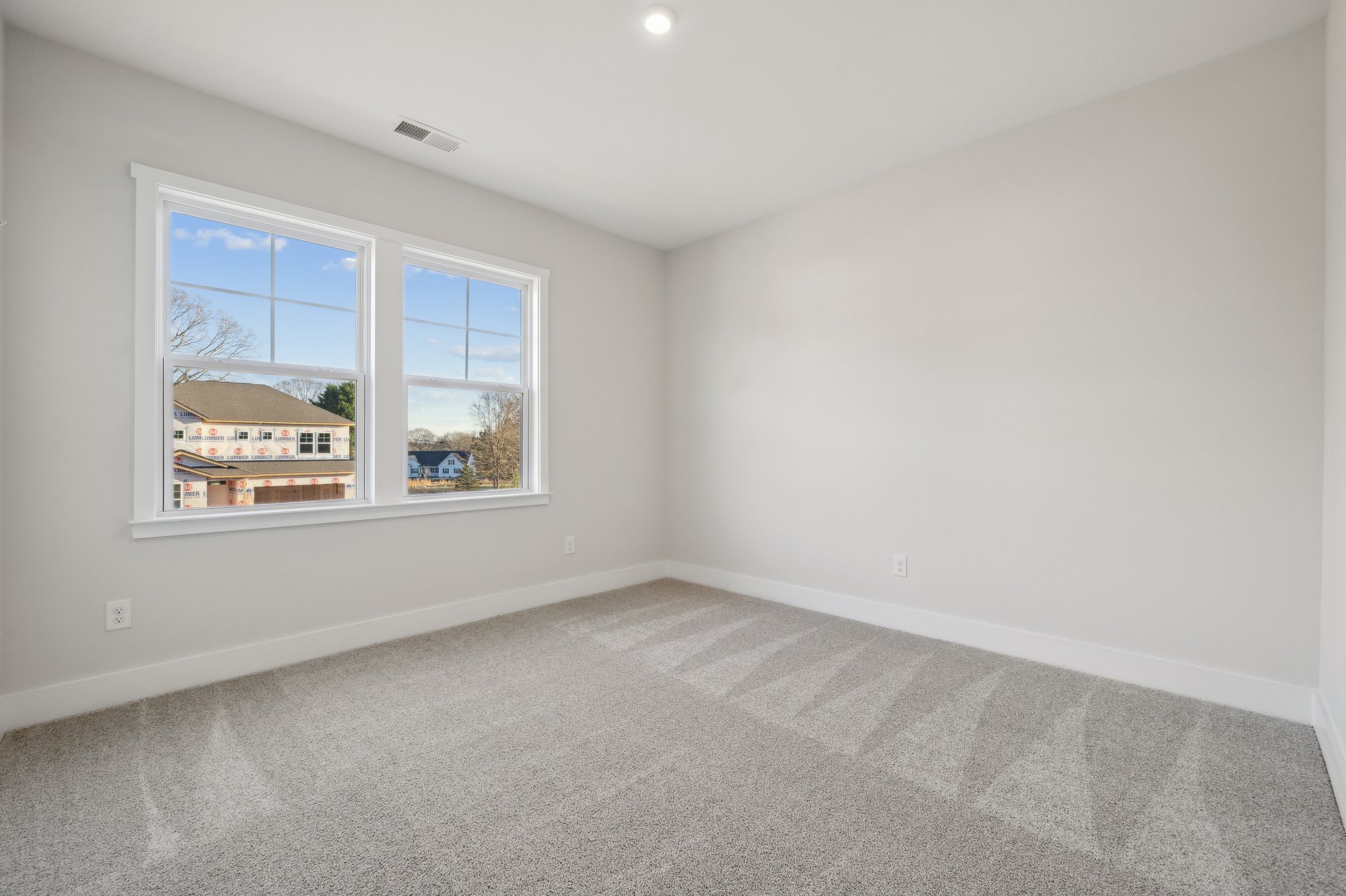 A room with a window and a carpet.