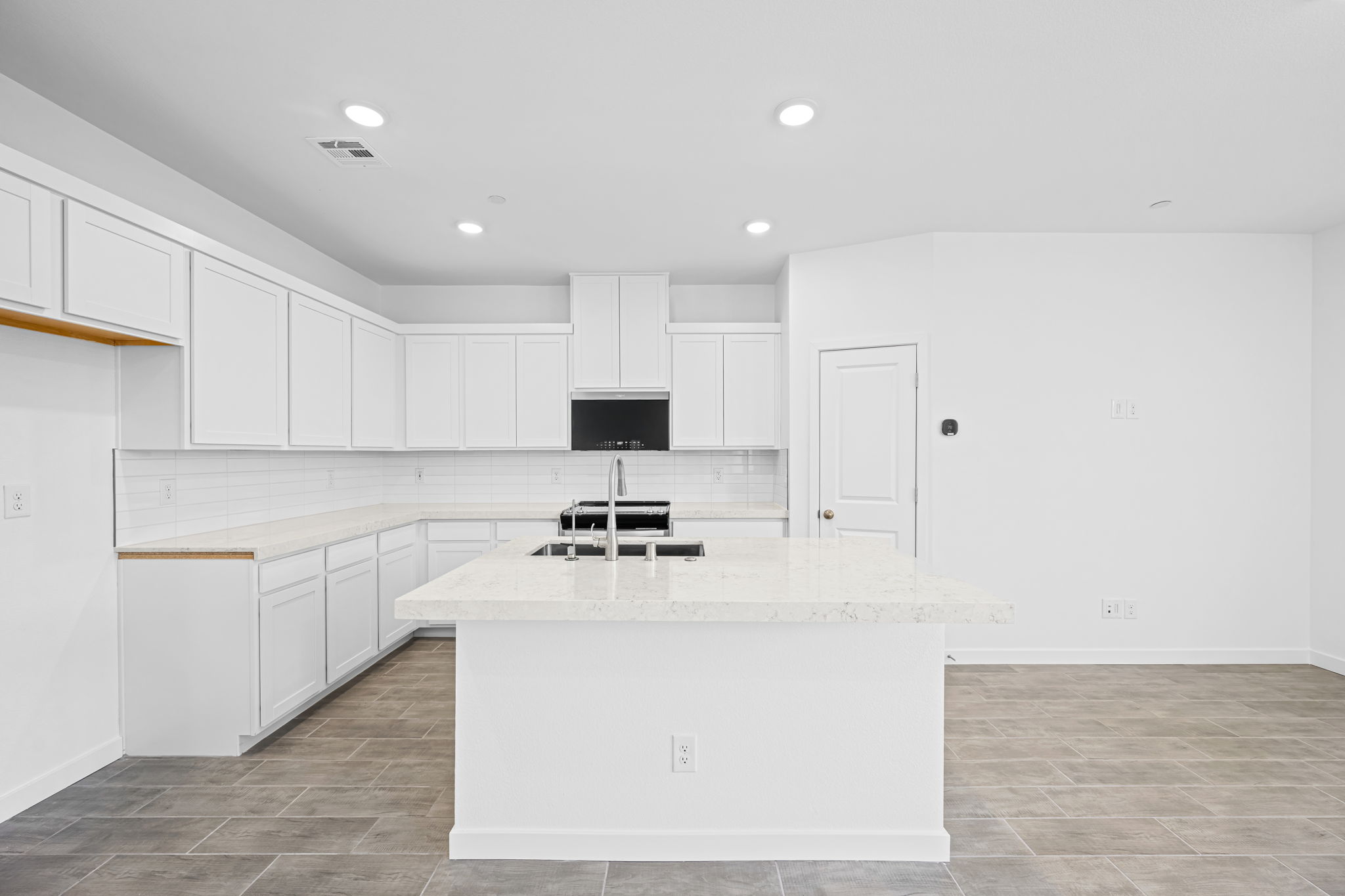 A kitchen with white cabinets.