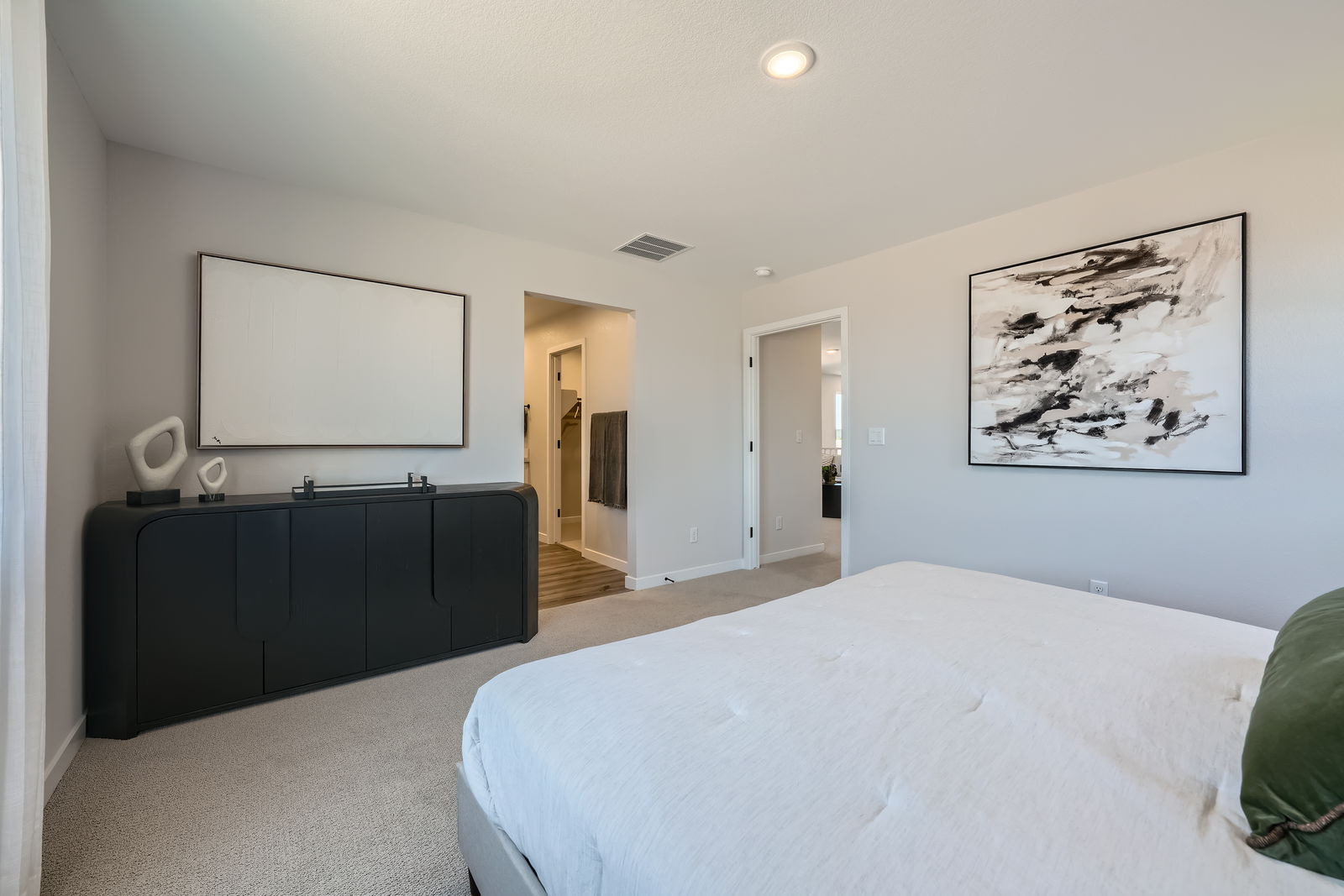 A bedroom with a bed and a painting on the wall.