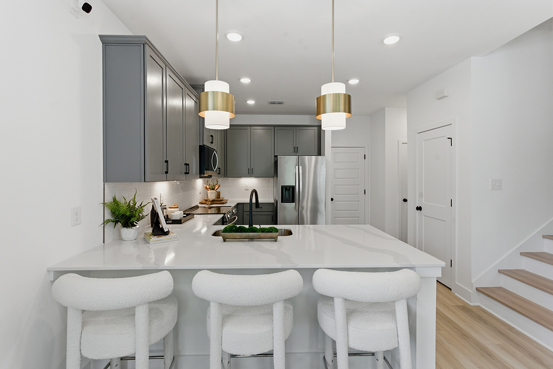 A kitchen with white cabinets.