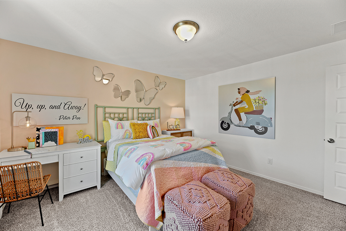 A bedroom with a bed and a chair.