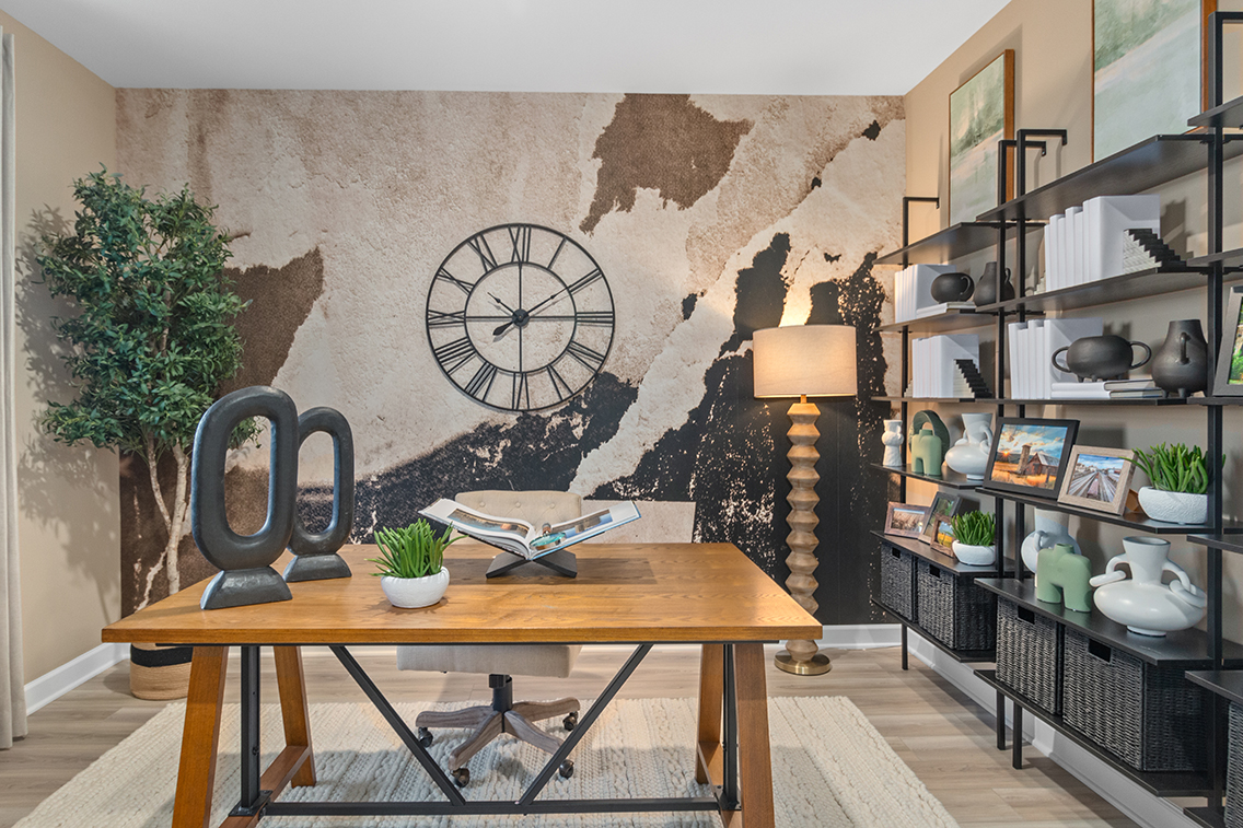 A table with a lamp and books on it in a room with shelves.