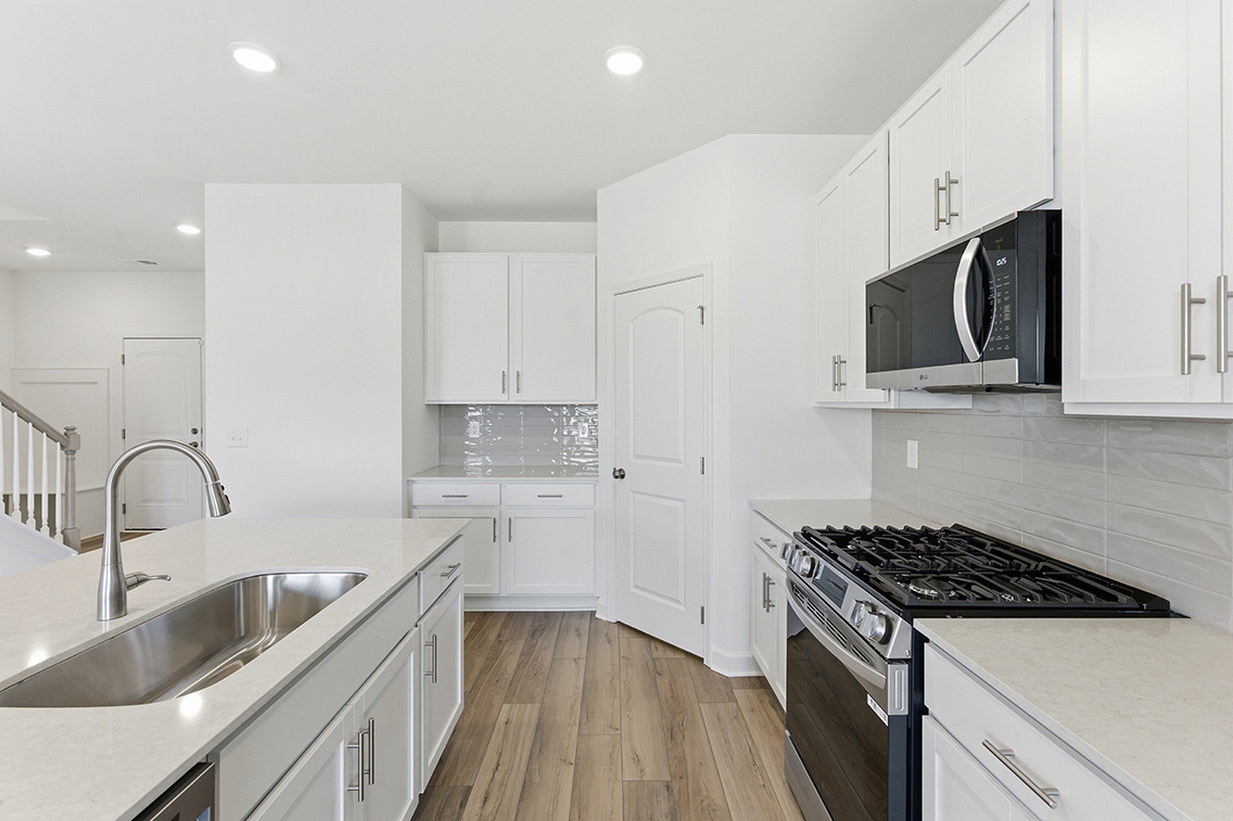 A kitchen with white cabinets.