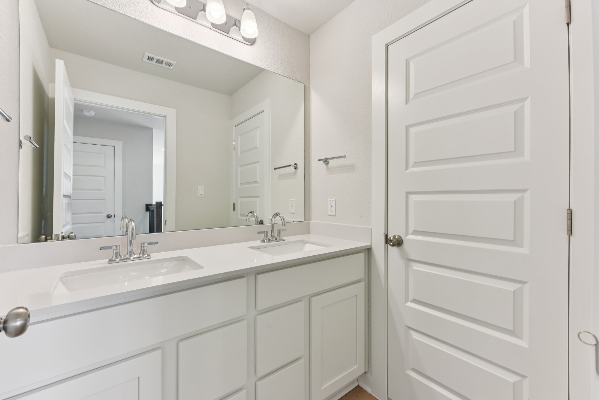 A bathroom with white cabinets.