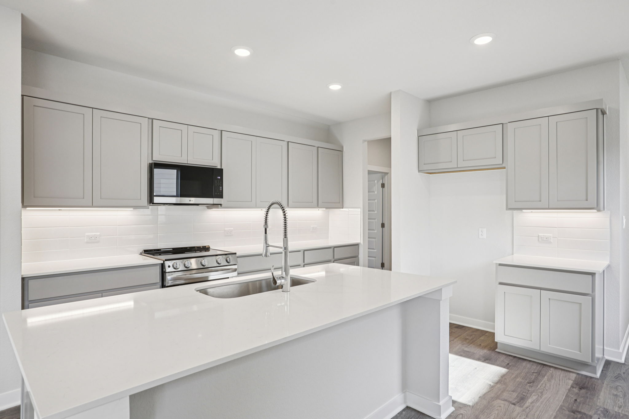 A kitchen with white cabinets.
