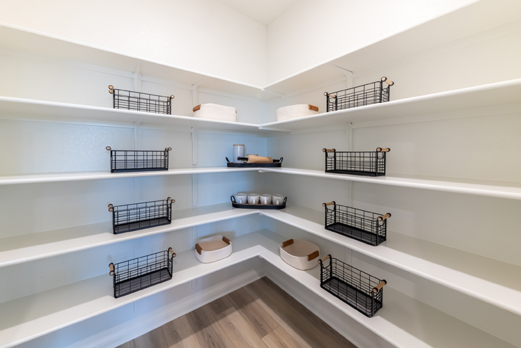 A white room with shelves and baskets.