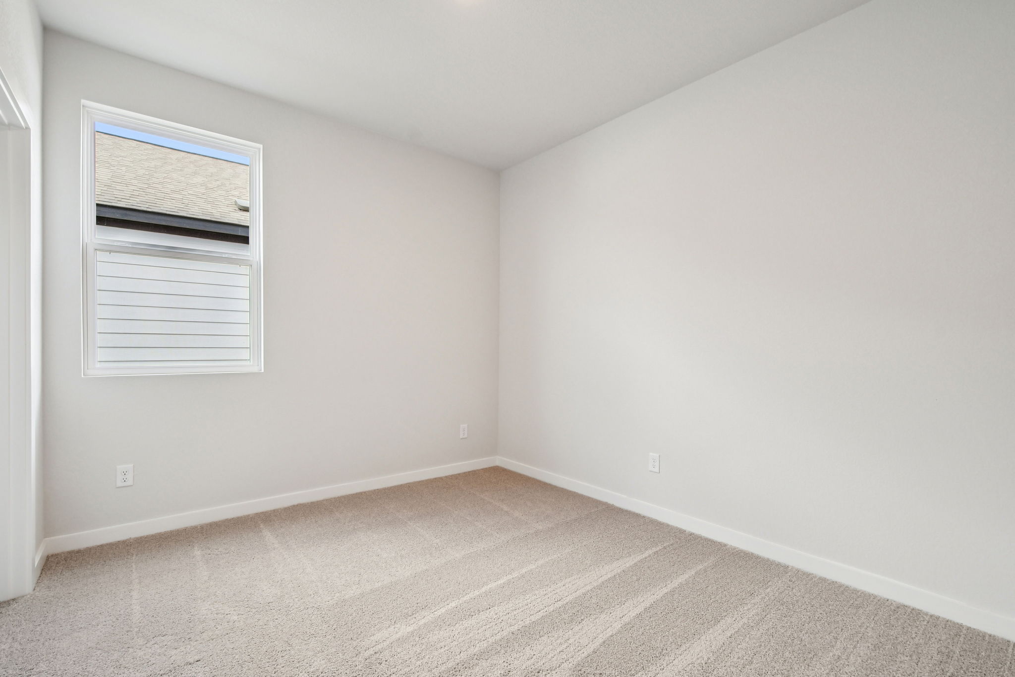 A room with a carpet and a window.