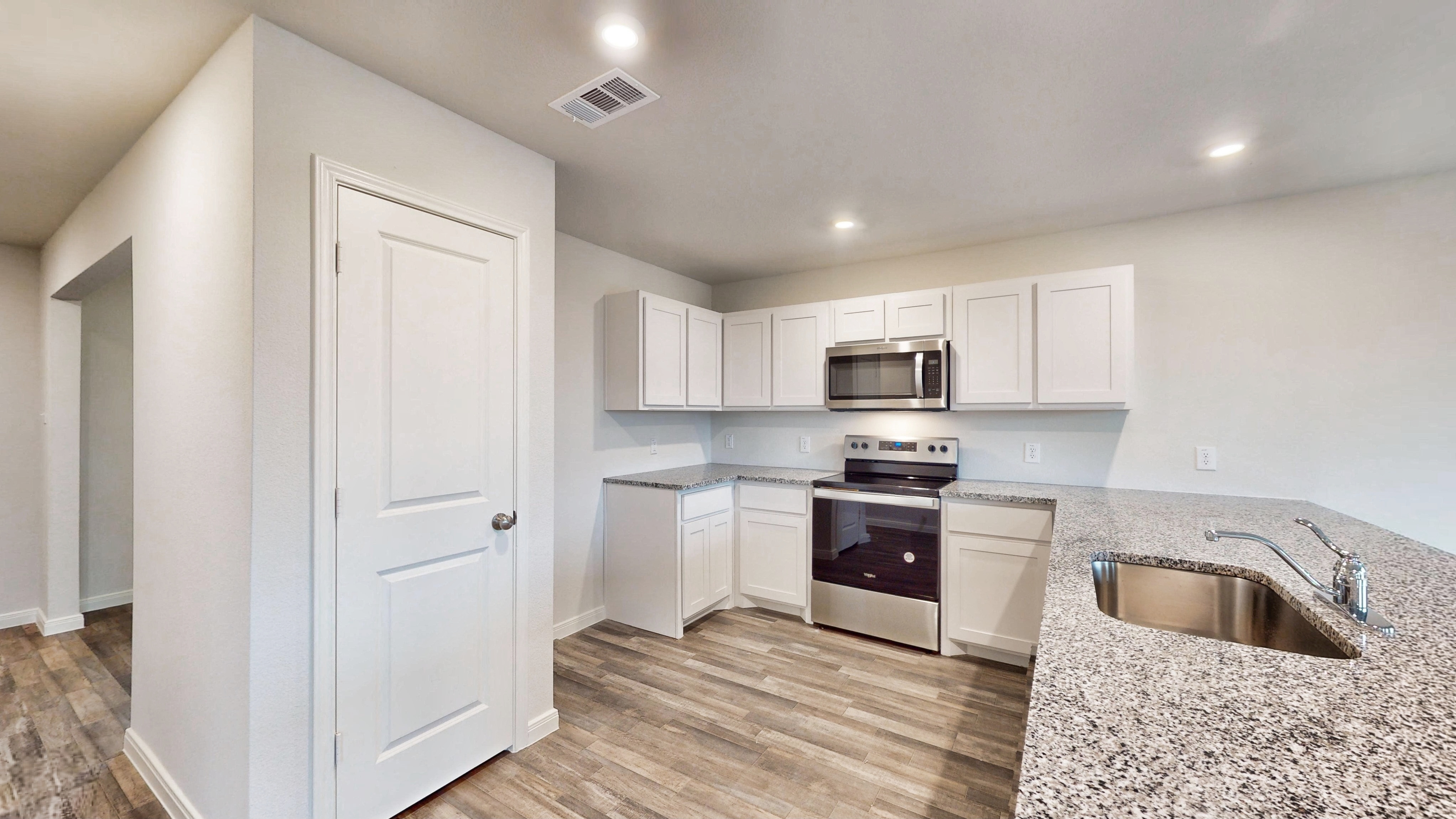 A kitchen with white cabinets.