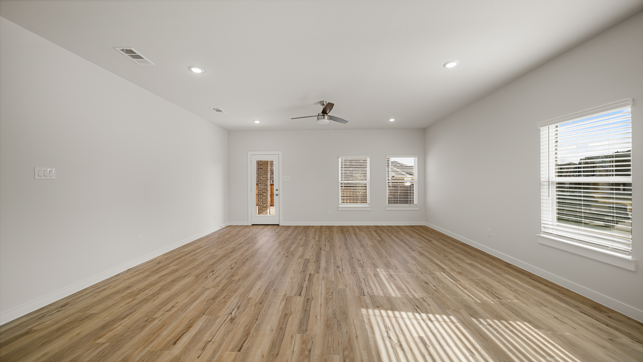 A room with a wood floor and a ceiling fan.