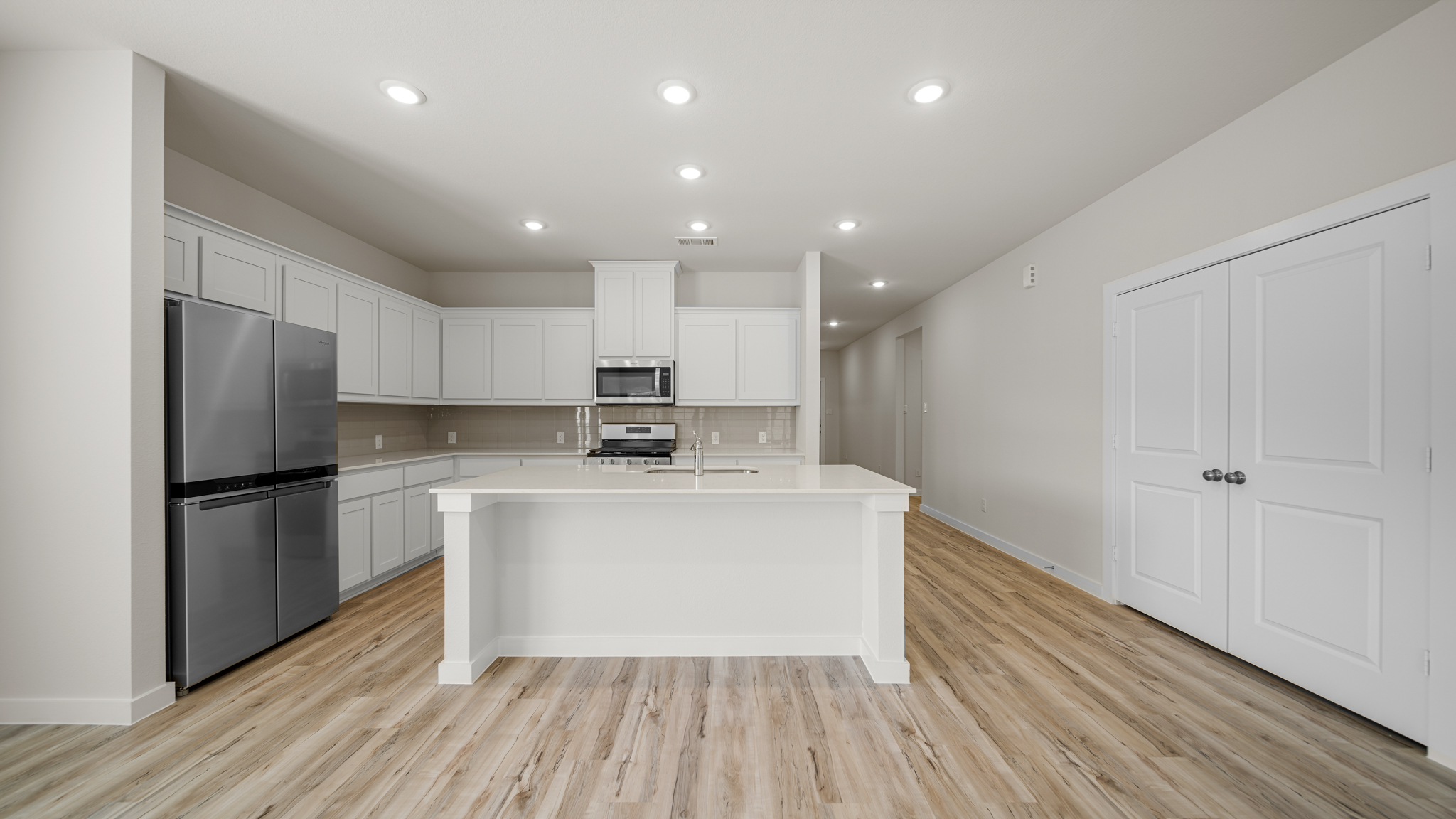 A kitchen with white cabinets.