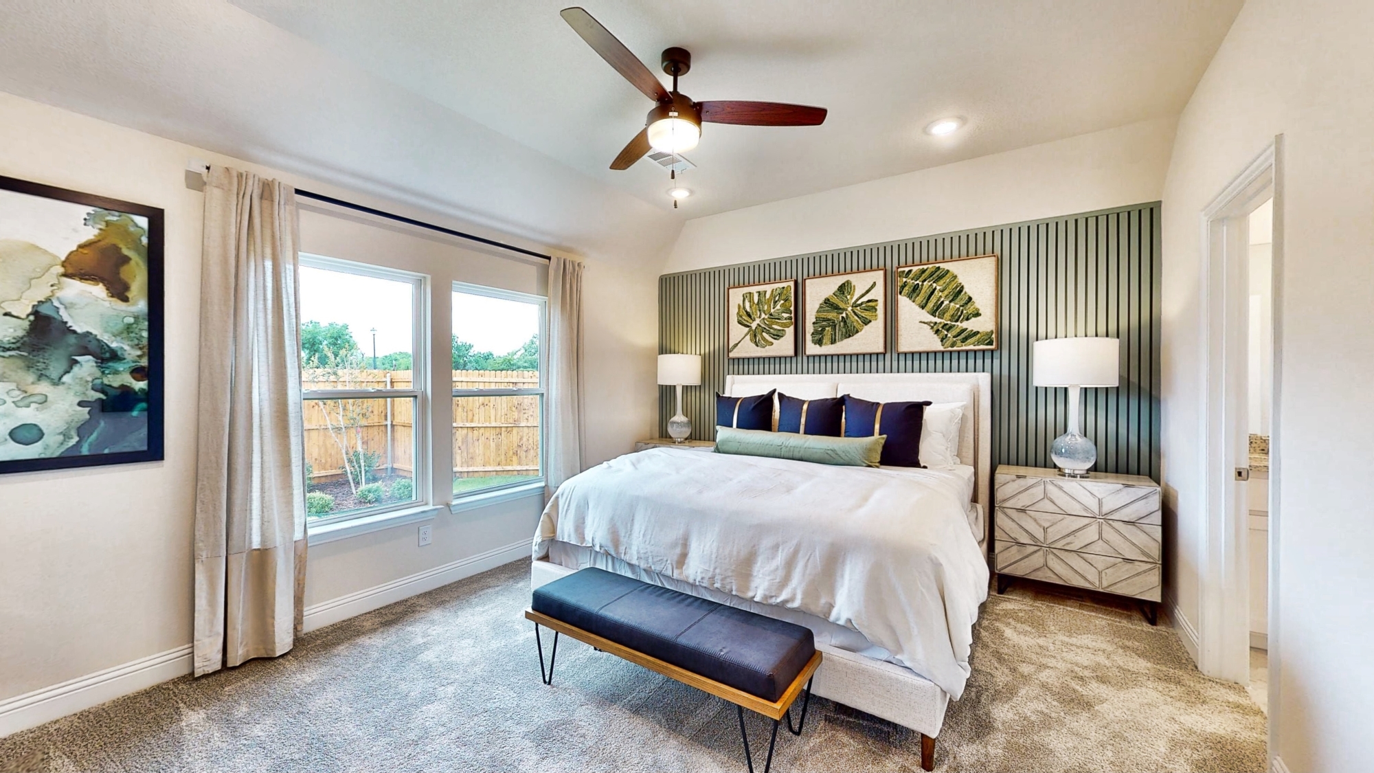 A bedroom with a bed and a bench.